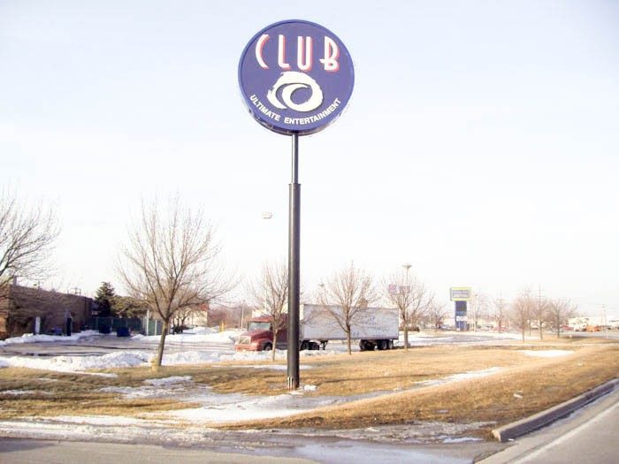 A monument sign with the name and logo of a business in a parking lot, representing how one can benefit from calling an Orland Park sign company.