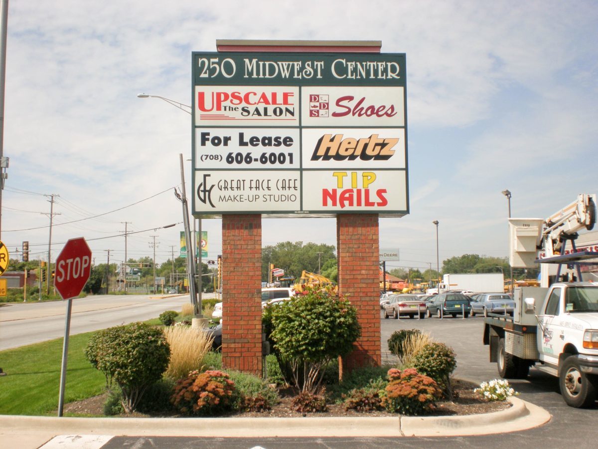 A monument sign outside a parking lot with a lot of names and logos of businesses, representing how one can benefit from calling a Schererville, IN sign company.