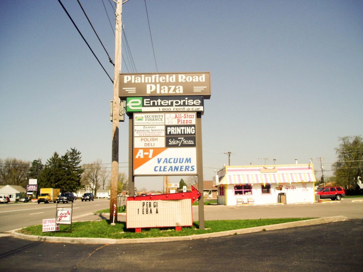 A monument sign with the names and logos of multiples business in a parking lot, representing how one can benefit from calling a Tinley Park sign company.