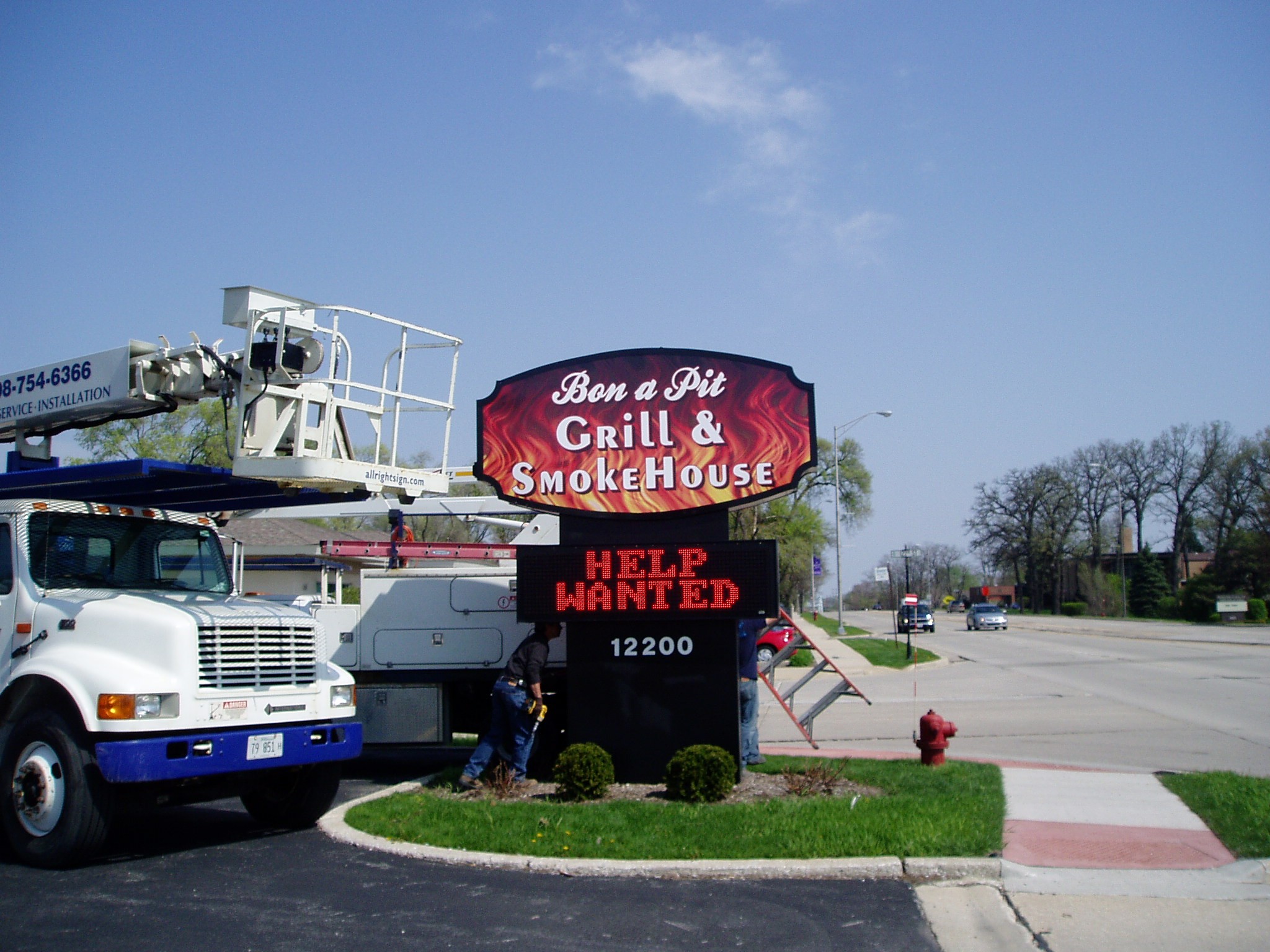 A monument, digital sign being installed in a parking lot, representing how one can benefit from calling a Tinley park commercial sign company.