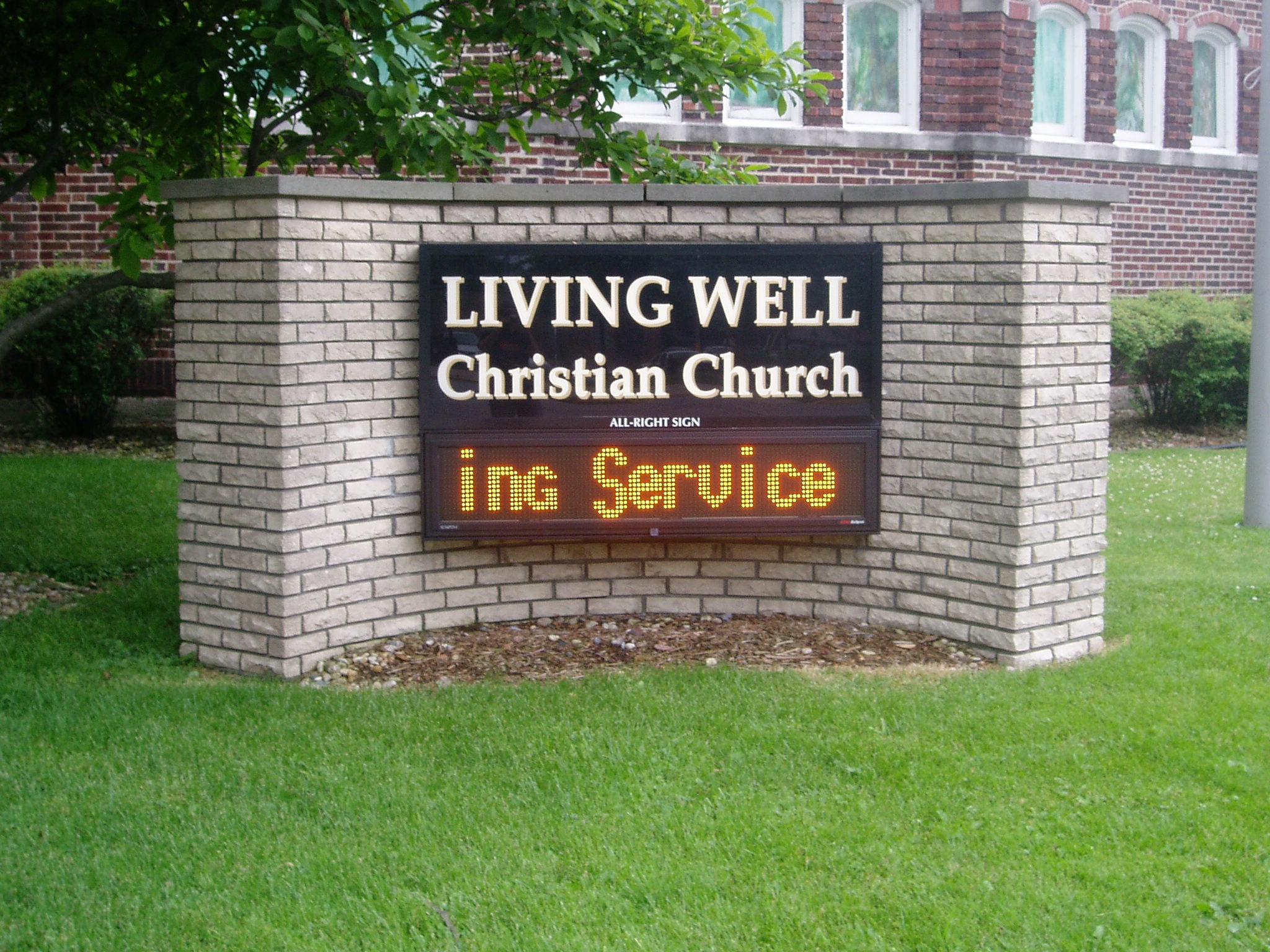 A monument, digital sign in a grassy area outside of a church, representing how one can benefit from calling a Merrillville digital sign company.