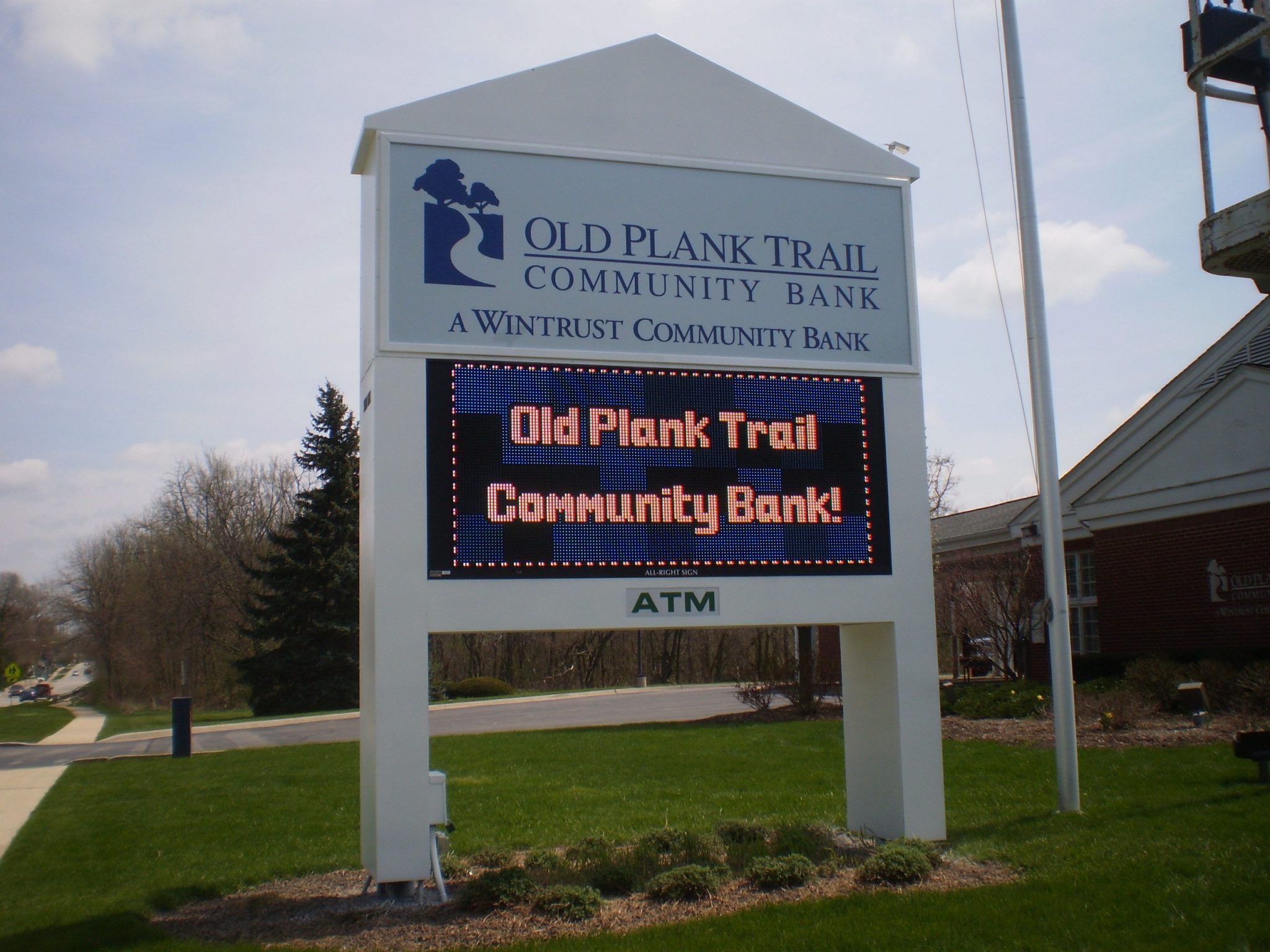 A white, outdoor digital sign for a bank, representing how one can benefit from calling a Joliet digital sign company.