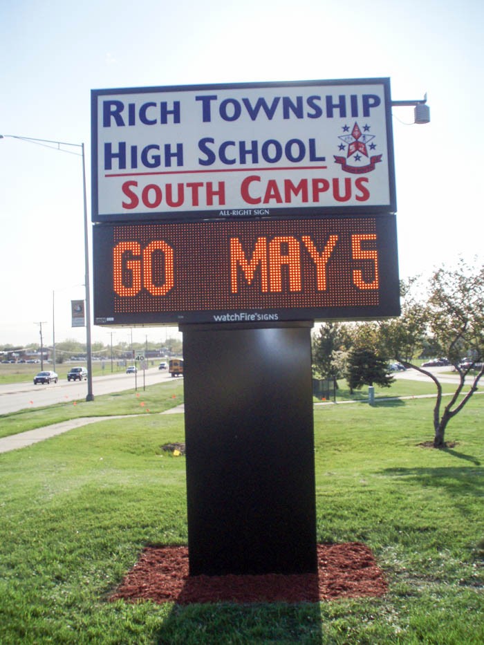 An outside digital sign for a school surrounded my grass, representing how one can benefit from calling a Merrillville, IN digital sign company.