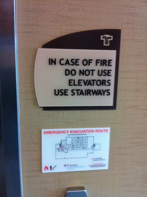 An interior sign giving instructions on what to do in case of fire, representing how one can benefit from contacting a sing company in Orland Park.