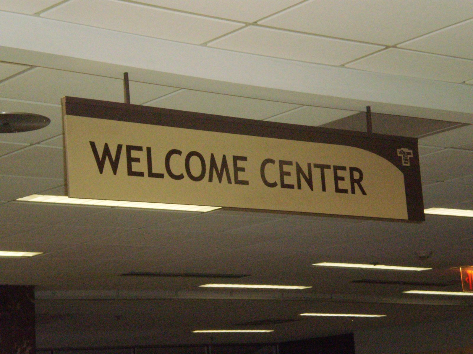 An indoor sign hanging from the ceiling that says "Welcome Center", representing how one can benefit from calling a sign installation company in Lake County, IN.