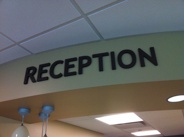 A large indoor sign that says "Reception", representing how one can benefit from calling a sign company in St. John, IN.