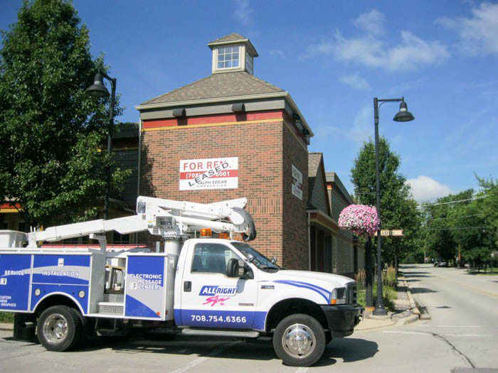 A constructions truck park outside of a building in the street, representing how one can benefit from calling a Merrillville sign company.