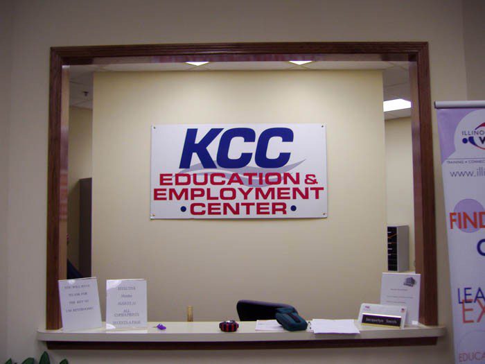 A large wall sign inside of a building behind a desk, representing how one can benefit from calling a Merrillville sing company.
