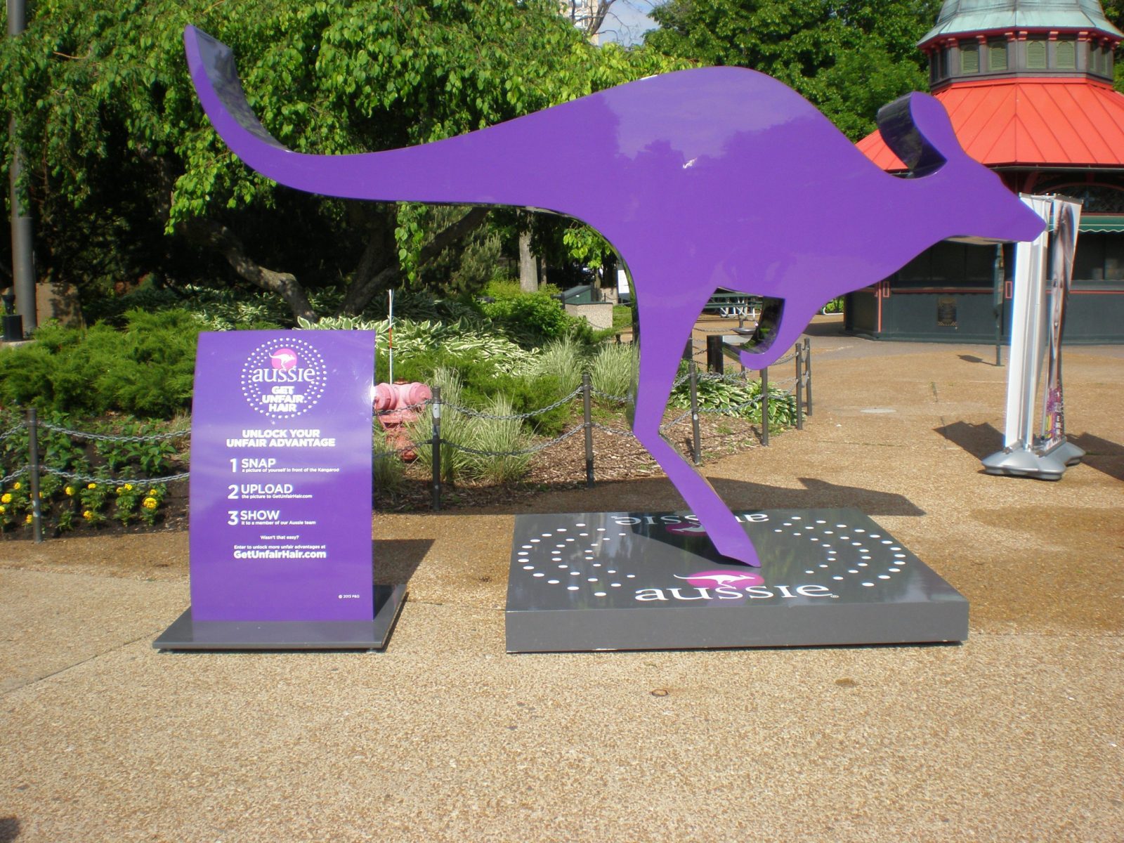 A big purple sign in a shape of a kangaroo and a smaller purple sign next to with instructions, representing how one can benefit from calling a Chicago sign company.