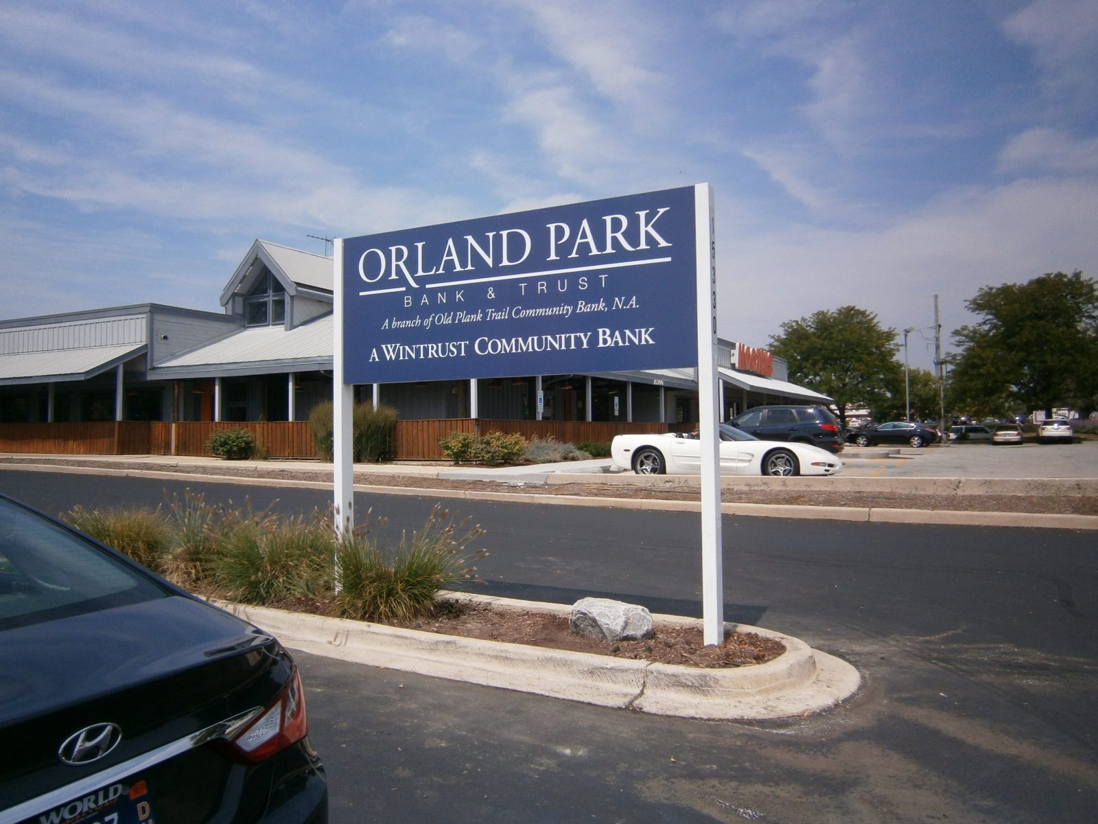 A white and blue panel sign in a grassy area, representing how one can benefit from calling a Tinley Park sign company.