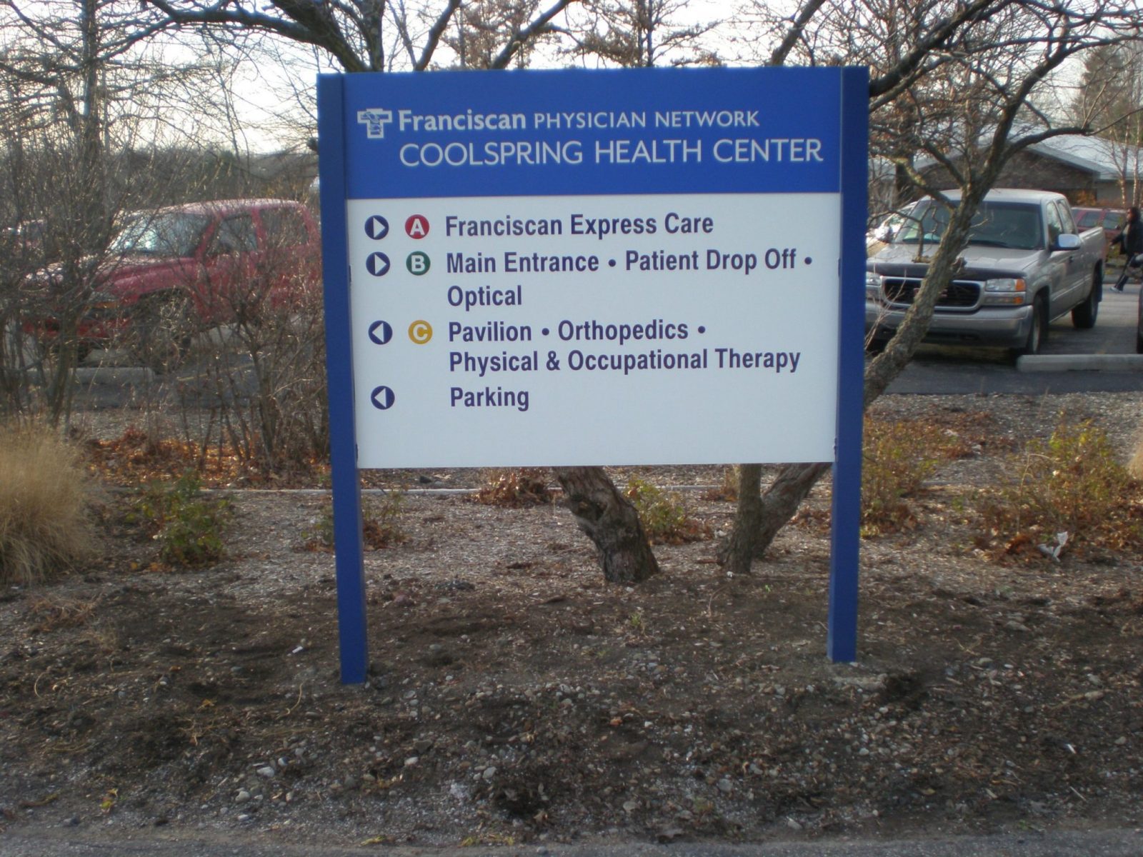 A blue and white post sign in a parking lot, representing how one can benefit from calling a Chicago sign company.