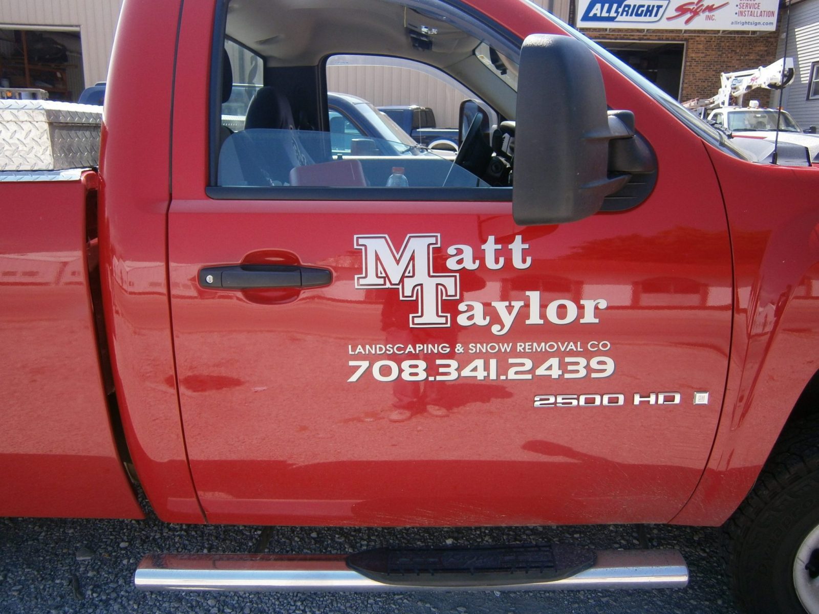 A red truck with multiple graphic fleets, representing how one can benefit from calling a Merrillville commercial truck lettering company.