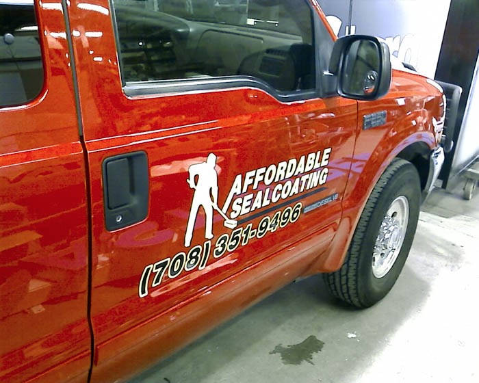 A red truck with multiple graphic fleets, representing how one can benefit from calling a Cook County, IL commercial truck lettering company.