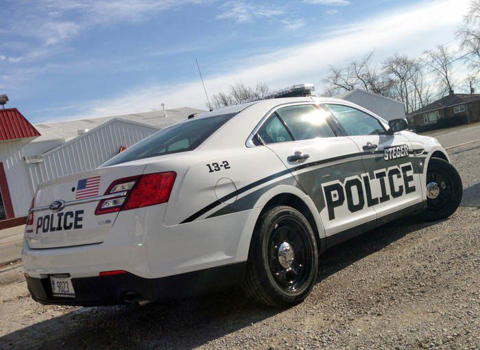 A white police car with many graphic fleets, representing how one can benefit from calling a Lake County, IL commercial truck lettering company.