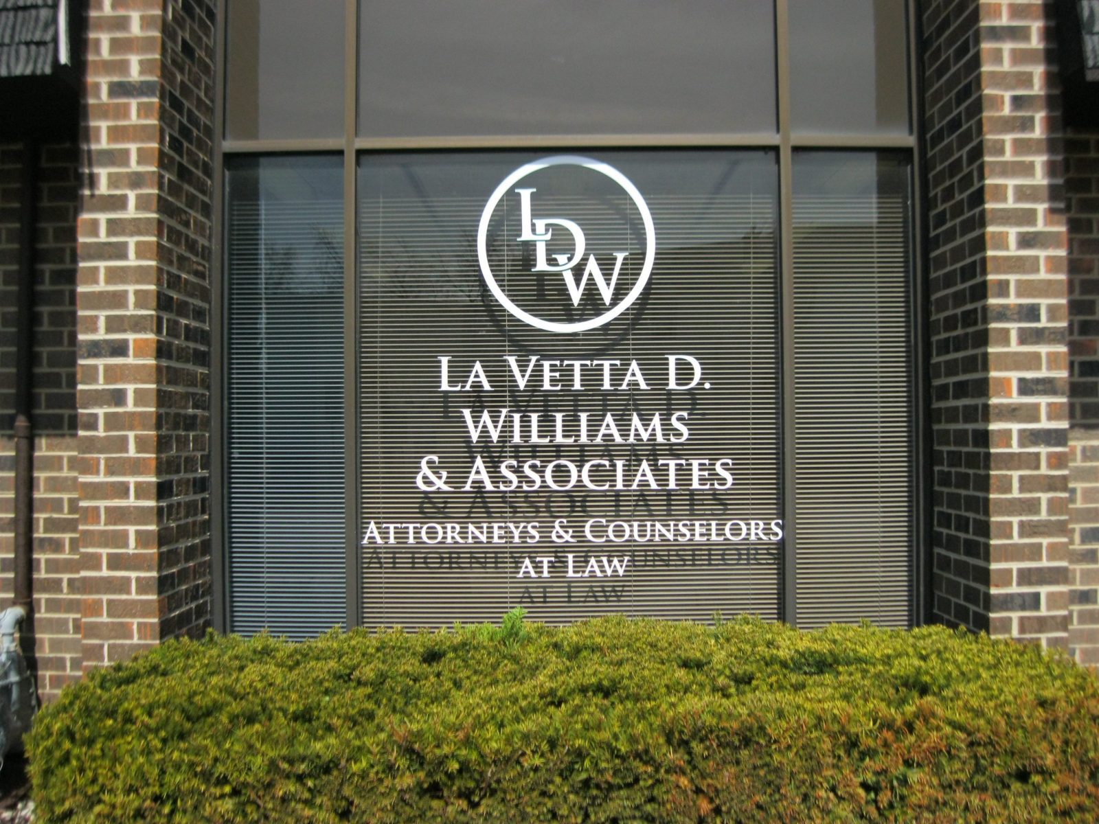 A white printed signed on a window for a Law Firm, representing how one can benefit from calling a sign installation company in St. John, IN.