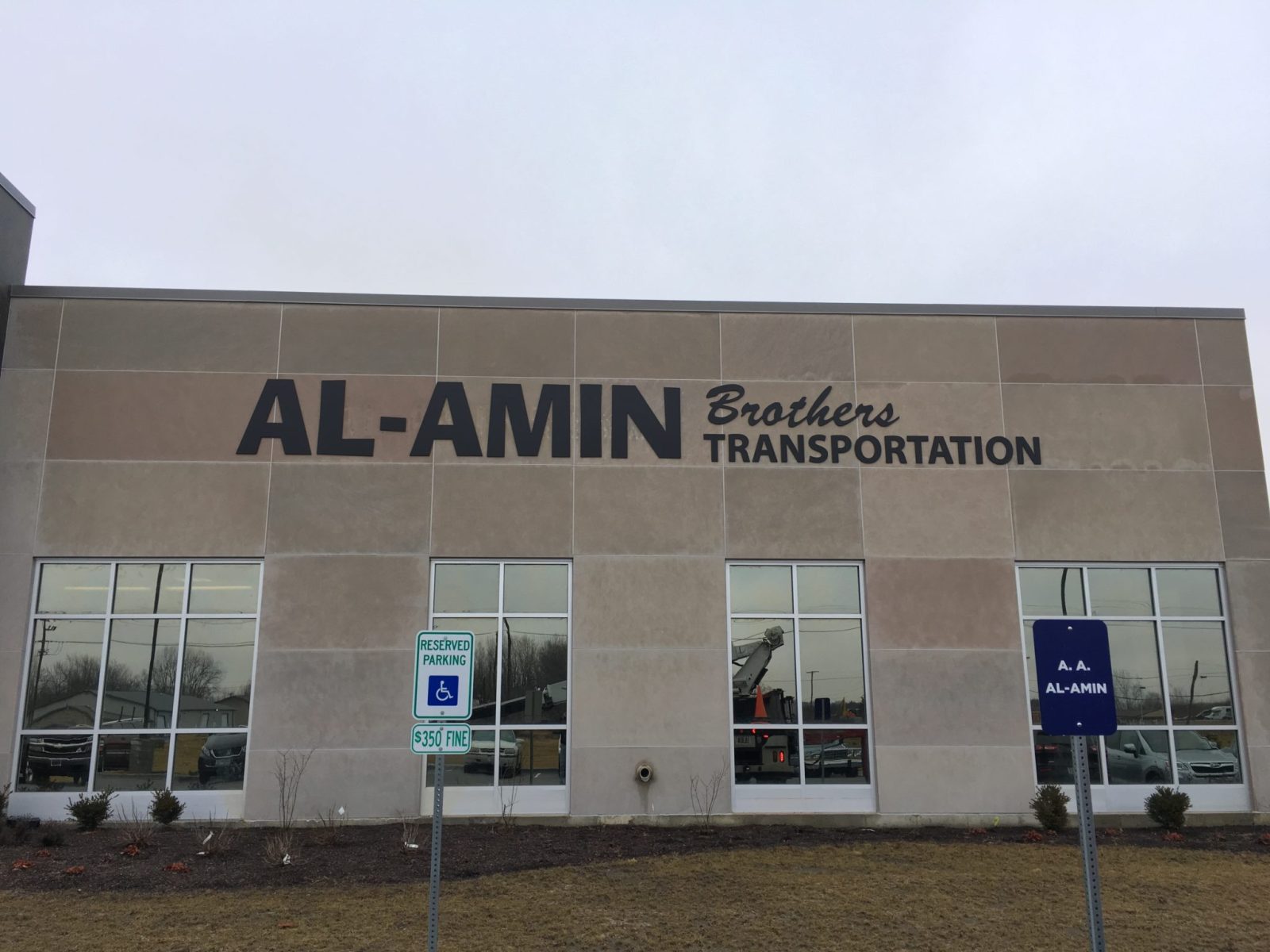 The outside of a building with a big beautiful sign with channel letters that says "Al-Amin Brothers Transportation", representing how one can benefit from calling a sign installation company in Chicago.