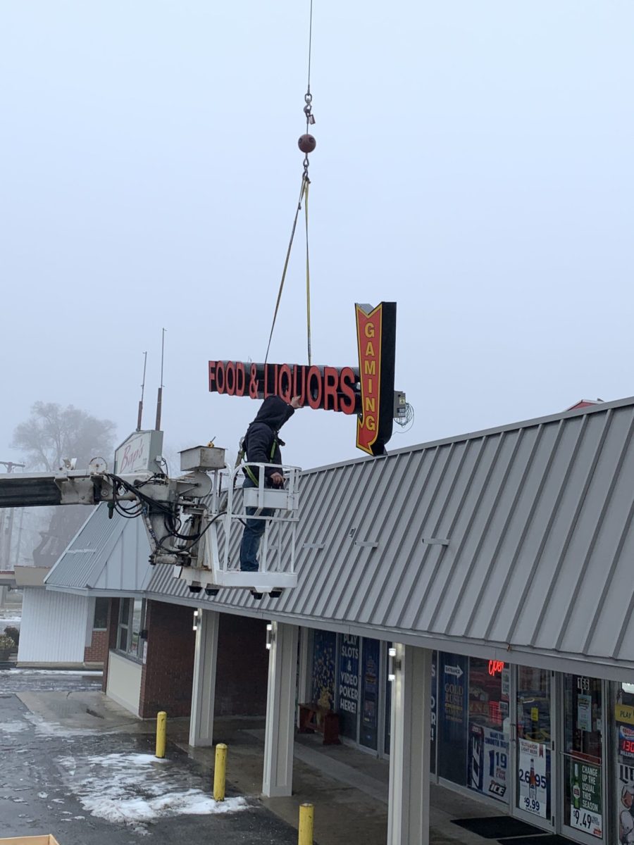 A crew installing a sign in a local business, representing how one can benefit from calling the best company for channel letters signs in Chicago.