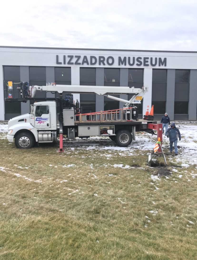 A truck outside of a building with crew works, they building has a sign that says "Lizadro Museum", representing how one can benefit from calling a Chicago commercial sign installation company.