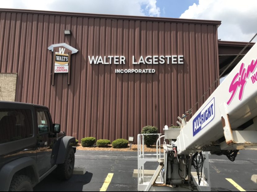 The parking lot of a business, it is a brow building with a sing that says "Walter Lagestee" representing how one can benefit from calling a commercial sign company in Orland Park.